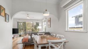 a white living room with a table and chairs at Nelson By The Bay in Apollo Bay