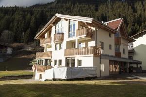 a large white building with balconies and a yard at Haus Sonneneck - ski in & out in Sankt Anton am Arlberg