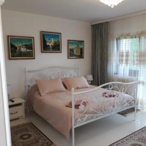 - une chambre avec un lit blanc et une fenêtre dans l'établissement Sunčani Breg Apartments Vrdnik, à Vrdnik