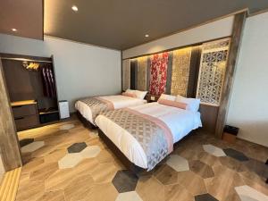 1 dormitorio con 2 camas y TV. en Marukyoo, en Nikko
