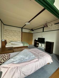 a bedroom with two beds and a television in it at 民宿 渡辺 in Iwanai
