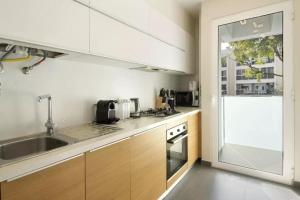 eine Küche mit weißen Schränken und einer Spüle in der Unterkunft 1 Bed Apartment Sleeps 4 with Pool in Santo António