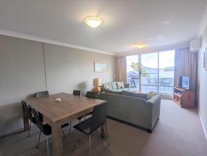 a living room with a table and a couch at Horizons 219/10 Kosciuszko Road in Jindabyne