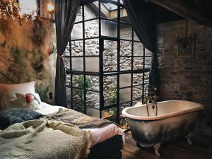 a bedroom with a bath tub and a window at Rêve Aveyron in Broquiès