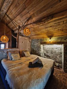 um quarto com uma cama grande e tectos em madeira em Rêve Aveyron em Broquiès