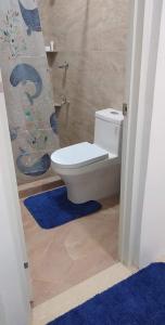 a bathroom with a toilet and a blue rug at Donadel Hometel in Iloilo City