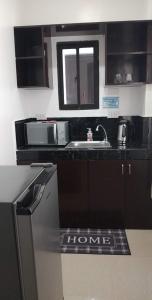 a kitchen with a sink and a microwave at Donadel Hometel in Iloilo City