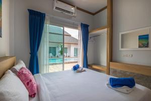 a bedroom with a bed and a large window at Amadha Villas Retreat - Free Tuk-Tuk Service To the Beach in Ao Nang Beach