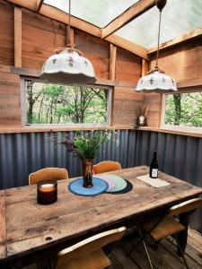 a wooden table with a vase on it in a room at Rêve Aveyron in Broquiès +46 photos