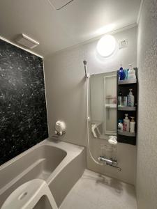 a bathroom with a bath tub and a sink at 民宿 渡辺 in Iwanai