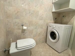 a bathroom with a toilet and a washing machine at The Sunny Lake - Apartment with Pool in Desenzano del Garda