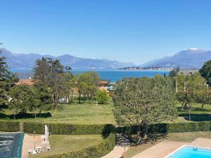 een resort met een zwembad en uitzicht op het water bij The Sunny Lake - Apartment with Pool in Desenzano del Garda