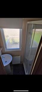 a small bathroom with a shower and a sink at 136 Beech at Flamingo Land in Malton