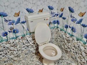 uma casa de banho com WC com borboletas na parede em Harbour town holiday home -malpe em Malpe