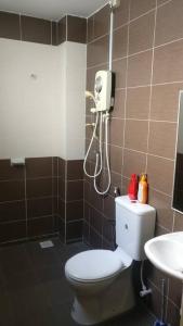y baño con aseo, ducha y lavamanos. en Setia Residen Semi-D 2.5 storey, unlimited wifi, en Sitiawan