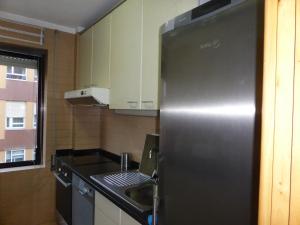 a kitchen with a stainless steel refrigerator and a sink at Apartment by the beach in Porto
