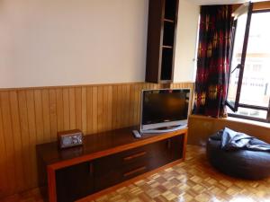 Apartment by the beach في بورتو: غرفة معيشة مع تلفزيون على طاولة خشبية