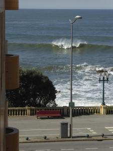 una luz de la calle junto a un banco y el océano en Apartment by the beach en Oporto