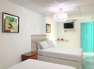 1 dormitorio con 2 camas y puerta azul en Pacific Coast Hotel, en Playa Bonita Village