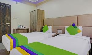 um quarto de hotel com duas camas com almofadas coloridas em Hotel Skylink Hospitality Next to Amber Imperial em Mumbai