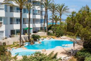 una imagen de una piscina del complejo con palmeras en Strandwohnung Marina Park Playa en Cala Millor