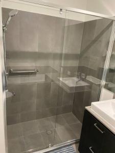 a glass shower in a bathroom with a sink at Stunning 2story villa Near Canal in Gold Coast