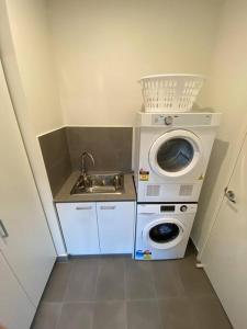 a small kitchen with a washing machine and a sink at Stunning 2story villa Near Canal in Gold Coast