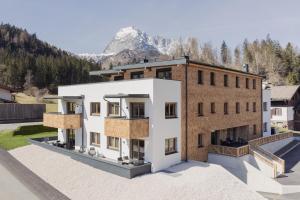 un revestimiento de un edificio con una montaña en el fondo en Apartment Streif LXL en Kirchdorf in Tirol