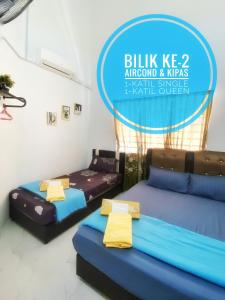 two beds in a room with a sign that reads blitz almond and mars at LH Homestay Bandar Utama Gua Musang in Gua Musang