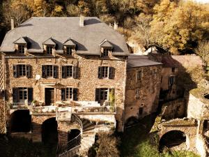 an old stone house with a roof on a bridge at Rêve Aveyron in Broquiès