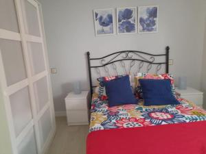 1 dormitorio con 1 cama con manta roja y almohadas azules en Alquiler integro casa próxima a Colunga, en Colunga