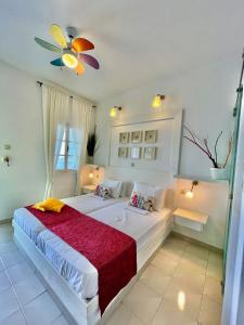 a bedroom with a large white bed with a red blanket at Villa Zografos in Irakleia