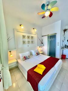 a bedroom with a large white bed with a ceiling fan at Villa Zografos in Iraklia