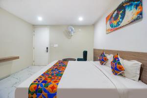 ein Schlafzimmer mit einem großen Bett mit einer bunten Decke in der Unterkunft FabHotel SSR Fern Suites in Lingampalli