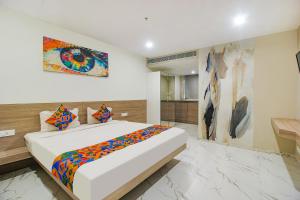 ein Schlafzimmer mit einem Bett und einem Wandgemälde in der Unterkunft FabHotel SSR Fern Suites in Lingampalli