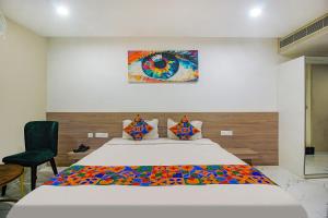 a bedroom with a large bed and a chair at FabHotel SSR Fern Suites in Lingampalli