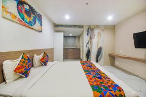 a bedroom with a large bed and a tv at FabHotel SSR Fern Suites in Lingampalli