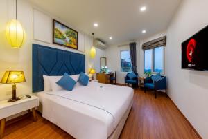a bedroom with a large white bed with blue accents at Babylon Grand Hotel & Spa in Hanoi