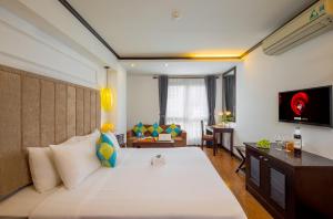 a bedroom with a large bed and a living room at Babylon Grand Hotel & Spa in Hanoi