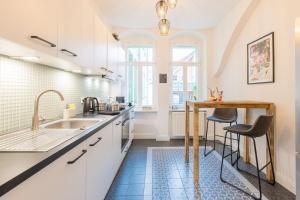 a kitchen with white cabinets and a sink and a table at Fynbos Apartments Theaterblick, Netflix, Parkplatz in Meißen