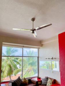 a living room with a ceiling fan and a large window at Apartamento amueblado en Acapulco in Acapulco