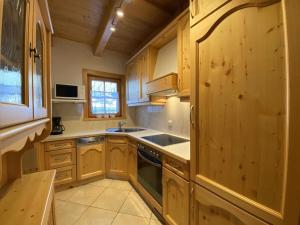 cocina con armarios de madera y horno con fogones en holiday home, Krimml, en Krimml