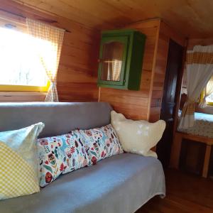 ein Sofa mit Kissen darauf im Zimmer in der Unterkunft Roulotte avec piscine la jonquille in Valgorge