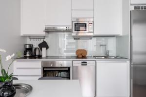 a kitchen with white cabinets and a stainless steel appliance at "Kapteeni" - 1BR Apartment next to Lake Pyhäjärvi, Hosted by 2ndhomes in Tampere +16 photos