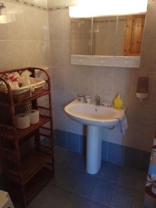 a bathroom with a white sink and a shelf at Villa in Skiathos in Kechria