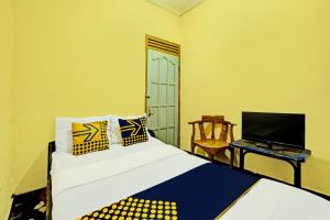 - une chambre avec un lit et un bureau avec un ordinateur portable dans l'établissement SPOT ON 92414 Hotel Pereng Sari, à Kopeng