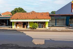 a building with an orange roof on the side of a street at OYO 92416 Salsabila Homestay in Pasuruan