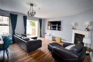a living room with two leather couches and a fireplace at Mourne Air & BBQ Shack in Newcastle