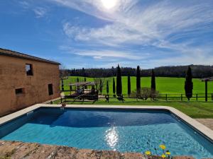 a large swimming pool in front of a house at Villa Le Caggia in Sovicille