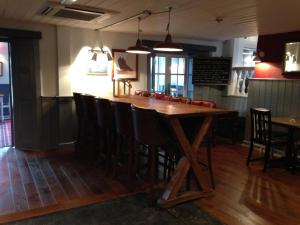 a bar in a restaurant with a wooden table at Dunstan House in Burnham on Sea